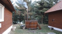 Traditional Wooden Hot Tub Outside The House With Smoke Rising From Chimney. static