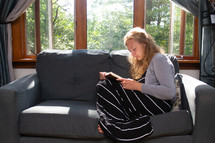 a woman reading a Bible on a couch 