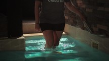 Young woman walking into baptistry.