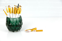 paint brushes in a green glass