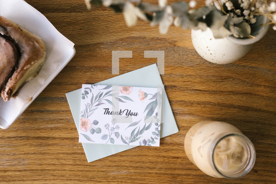 a thank you card on a wood table 