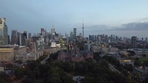 Aerial shot of dynamic downtown Toronto. Drone flying over Queen's Park showing the financial district with slightly moderate traffic during the afternoon. Slow camera movement to the right side.