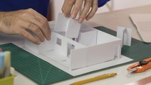 Professional male designer developing the construction of house model 
