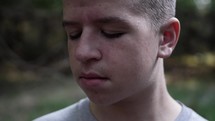 A sad young man crying. Teen boy with tears on his face in slow motion.