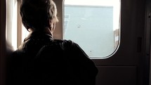 passenger looking out a train window 