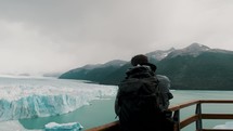 Backpacker With Camera Taking Pictures Of Perito Moreno Glacier On Argentino Lake In Los Glaciares National Park, Argentina. orbiting shot