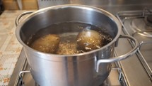 Boiling potatoes in a saucepot on a gas cooker
