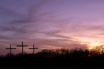 three crosses against a purple sky at sunrise background 