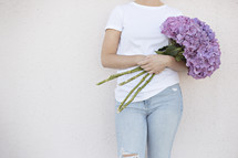 a woman holding a bouquet of hydrangeas 