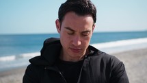 Sad And Pensive Man Dressed In Black On The Beach