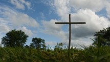 cross and grass and moving clouds 