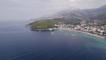 Drone view from over the Ionian Sea of the Ceraunian mountains, overlooking the beautiful beach town of Himare, Albania.