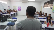Caring Teacher Explains Lesson to a Classroom Full of Brazil Children.