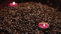 pile of coffee beans and votive candles 