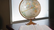 globe and opened Bible 