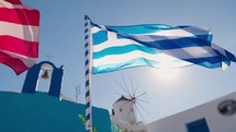 Slow motion of Greek flag rippling on the wind against blue sky in Santorini