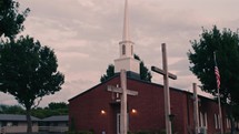 Crosses in front of a church with steeple