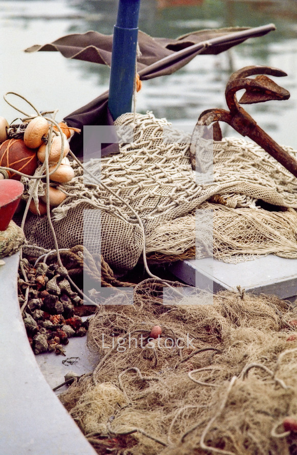 anchor and fishing nets in a fishing boat with a catch of seashells