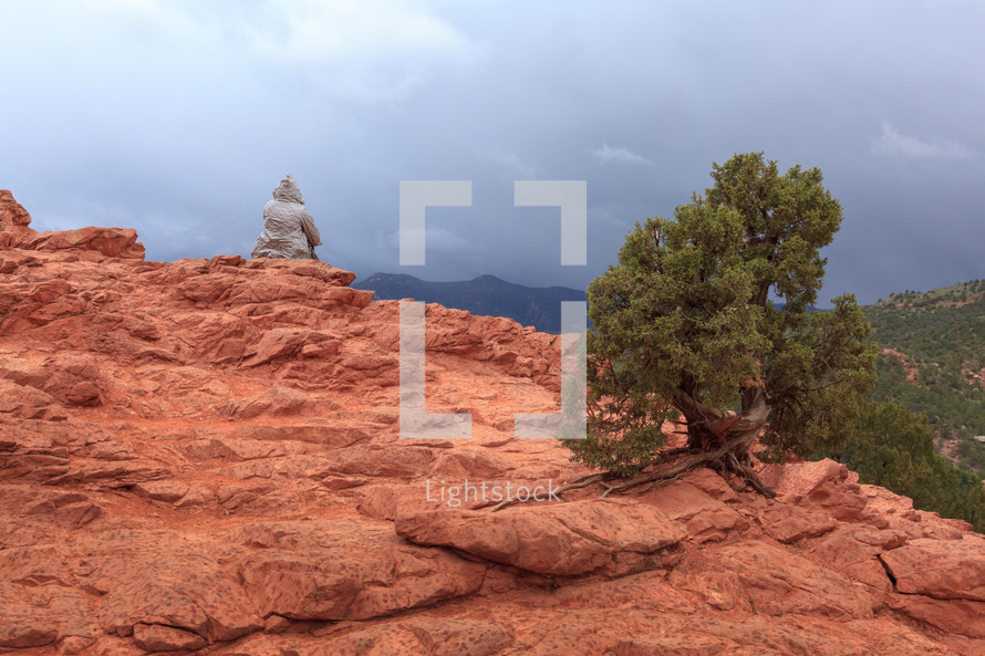 Person Sitting On Red Rock