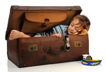 a child sleeping in a travel trunk 