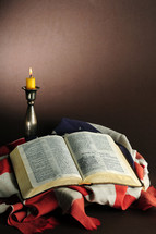 candlestick, American flag, and open Bible 