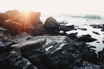 sunlight on rocks along a shore 