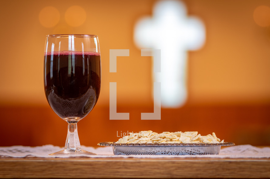 Christian communion grape juice in wine glass with unleavened bread matzah set at table in church