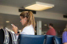 A woman looking at her phone in a waiting room