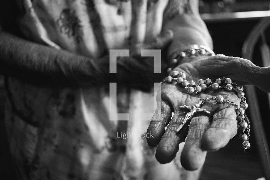 elderly woman holding a rosary 