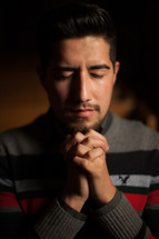 latino man with praying hands 