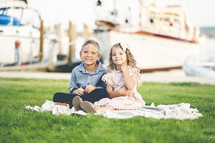 siblings portrait in front of a marina 