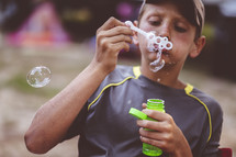child blowing bubbles 