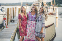 young women standing together in front of a marina 