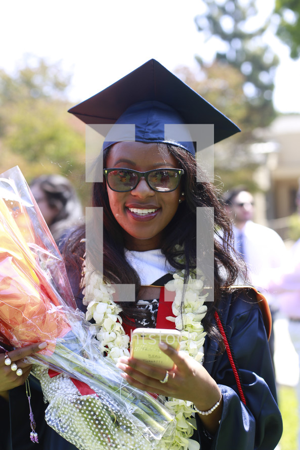 a smiling graduate holding flowers 
