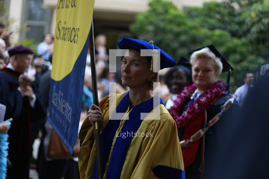 doctorate holding a banner at a graduation ceremony 