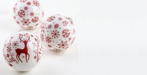 Three red and white Christmas balls on a white background.
