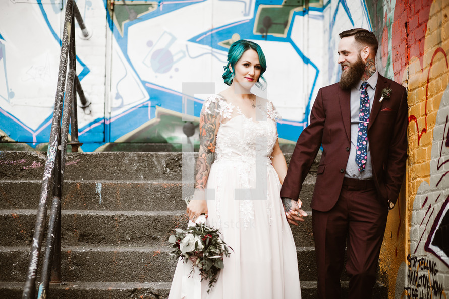 bride and groom in front of a graffiti covered wall 