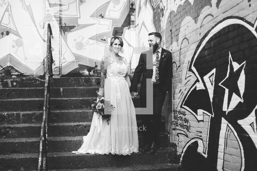 bride and groom in front of a graffiti covered wall 