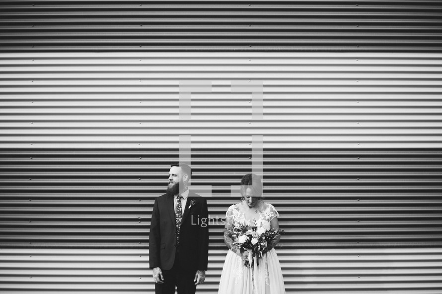 a bride and groom standing outdoors 