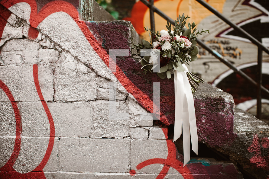 bridal bouquet on graffiti covered steps 
