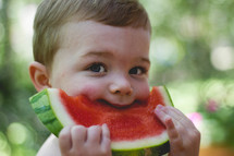 toddler eating a slice of watermelon 