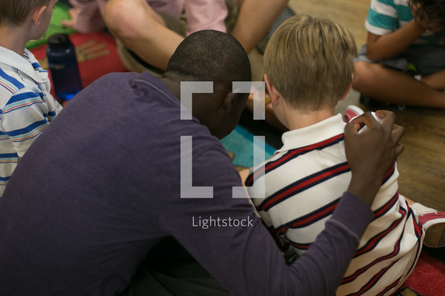 man with his arm around a child during a children's ministry
