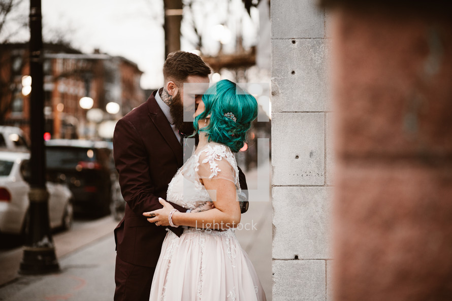 bride and groom kissing on a downtown sidewalk