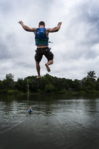 man jumping into a lake