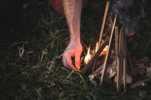 man lighting a campfire 