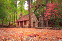 old mill wheel attached to stone building in georgia near the woods during autumn with fall foliage 