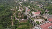 Drone view of Convent of Christ Aqueduct in Tomar, Portugal, surrounded by lush greenery