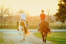 Two people riding horses.