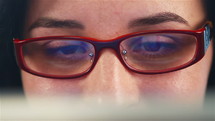 Businesswoman with glasses working on device: laptop or digital tablet computer - closeup