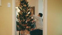 family decorating a Christmas tree 